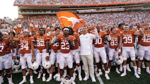 Texas football team salutes fans at end of game.